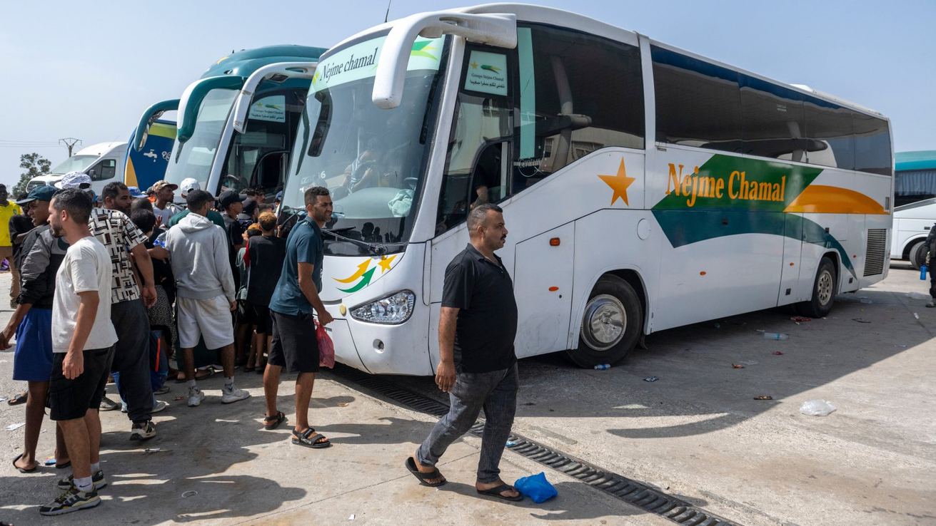 Ljudi se ukrcavaju u autobuse koje su obezbedile marokanske vlasti u Fnideku, Maroko, 1. avgusta 2026. godine, radi prevoza do njihovih gradova posle povratka iz španske eksklave Seute