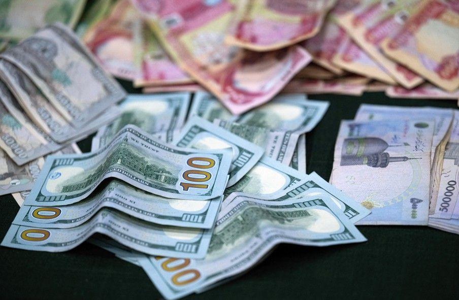 أوراق من الدينار والدولار في مركز لجمع التبرعات بمدينة البصرة في مارس/آذار 2026.