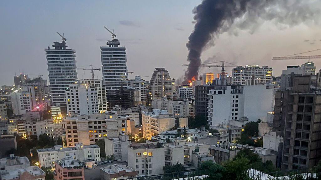 El humo sale desde los escombros de un edificio de medios de comunicación estatales iraníes en Teherán tras un ataque aéreo israelí el 16 de junio de 2025. 
