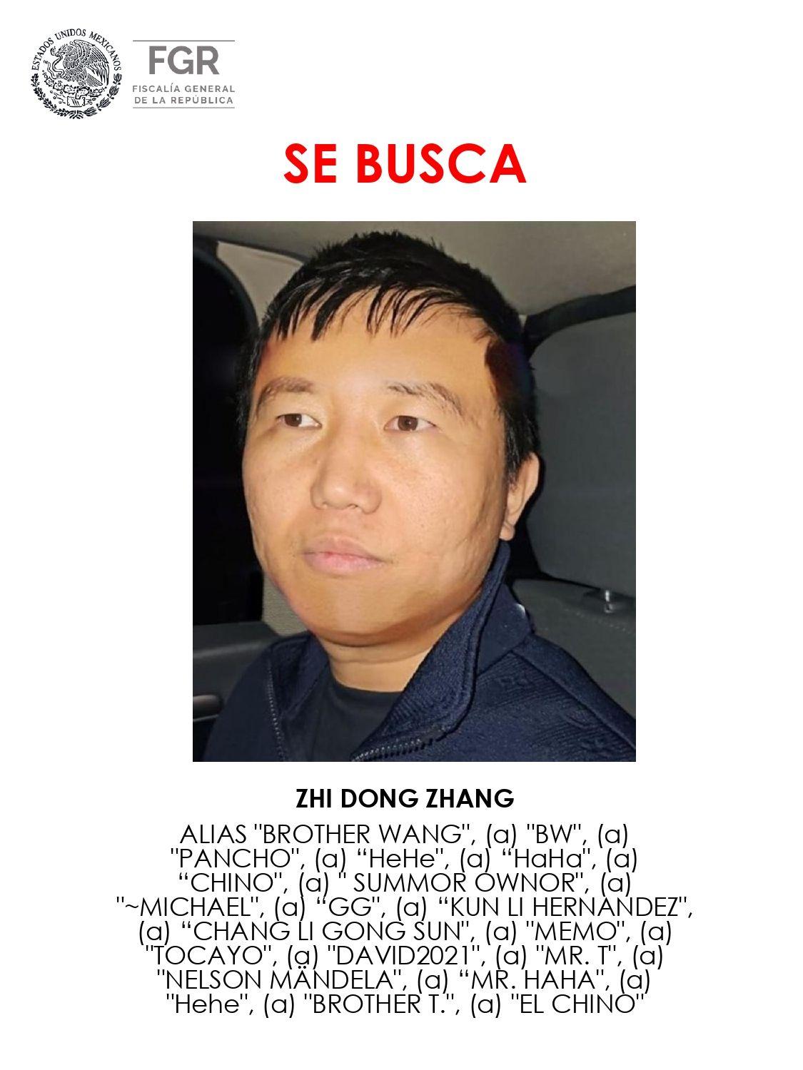 Nota de alerta emitida por la Fiscalía de Quintana Roo, México, donde se ve en el centro la foto de Zhi Dong Zhang en el interior de un auto, vestido con ropa deportiva, chaqueta azul oscura y camiseta negra. Encima, en letras rojas, "Se busca". Debajo de su foto, su nombre y, debajo, todos los apodos con los que se le conoce.