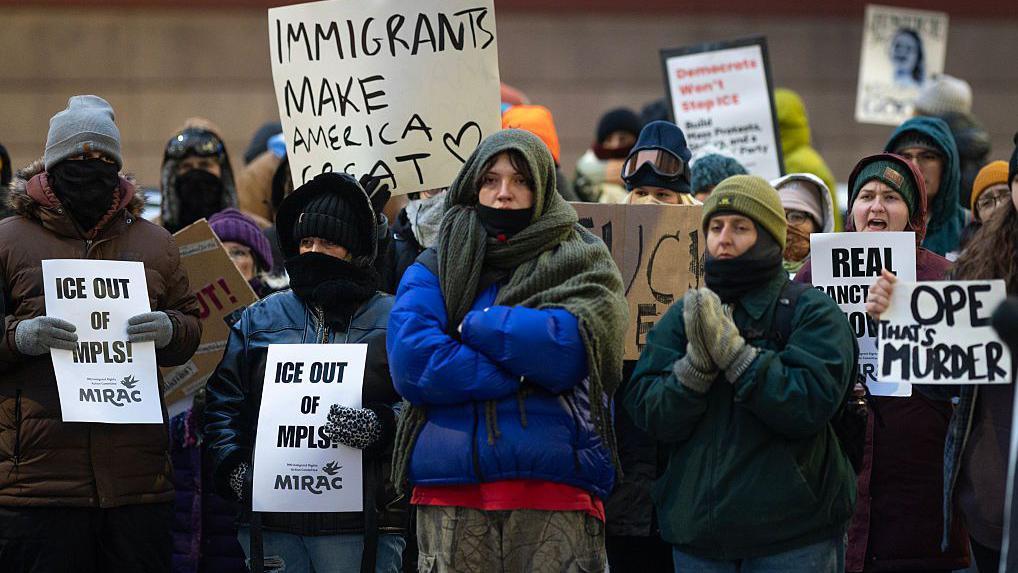 Un grupo de personas muy abrigadas contra el frío participan en Mineápolis en una protesta contra ICE.