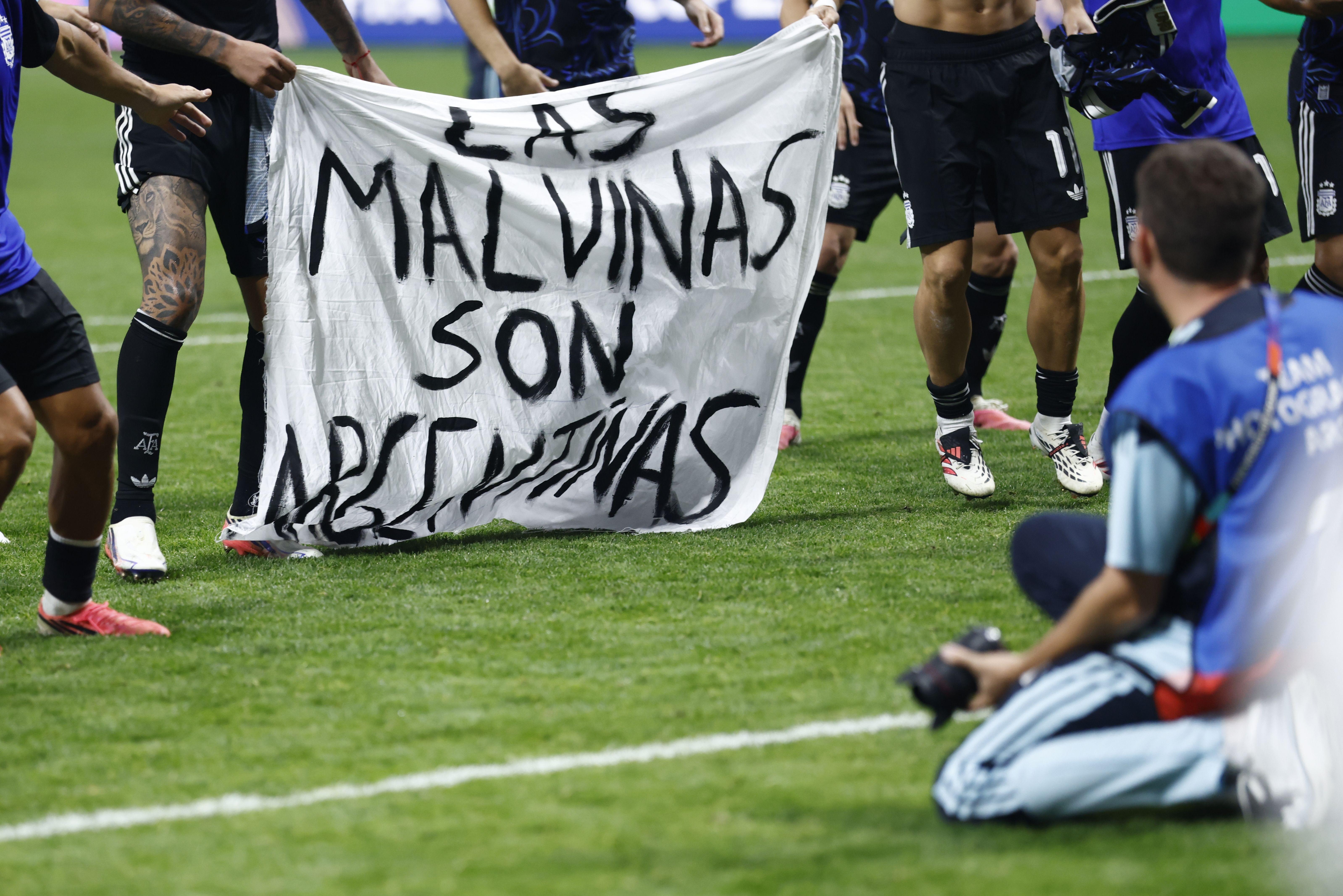 argentina, engleska - argentina, argentinski fudbaleri sa transparentom Malvini su argentinski