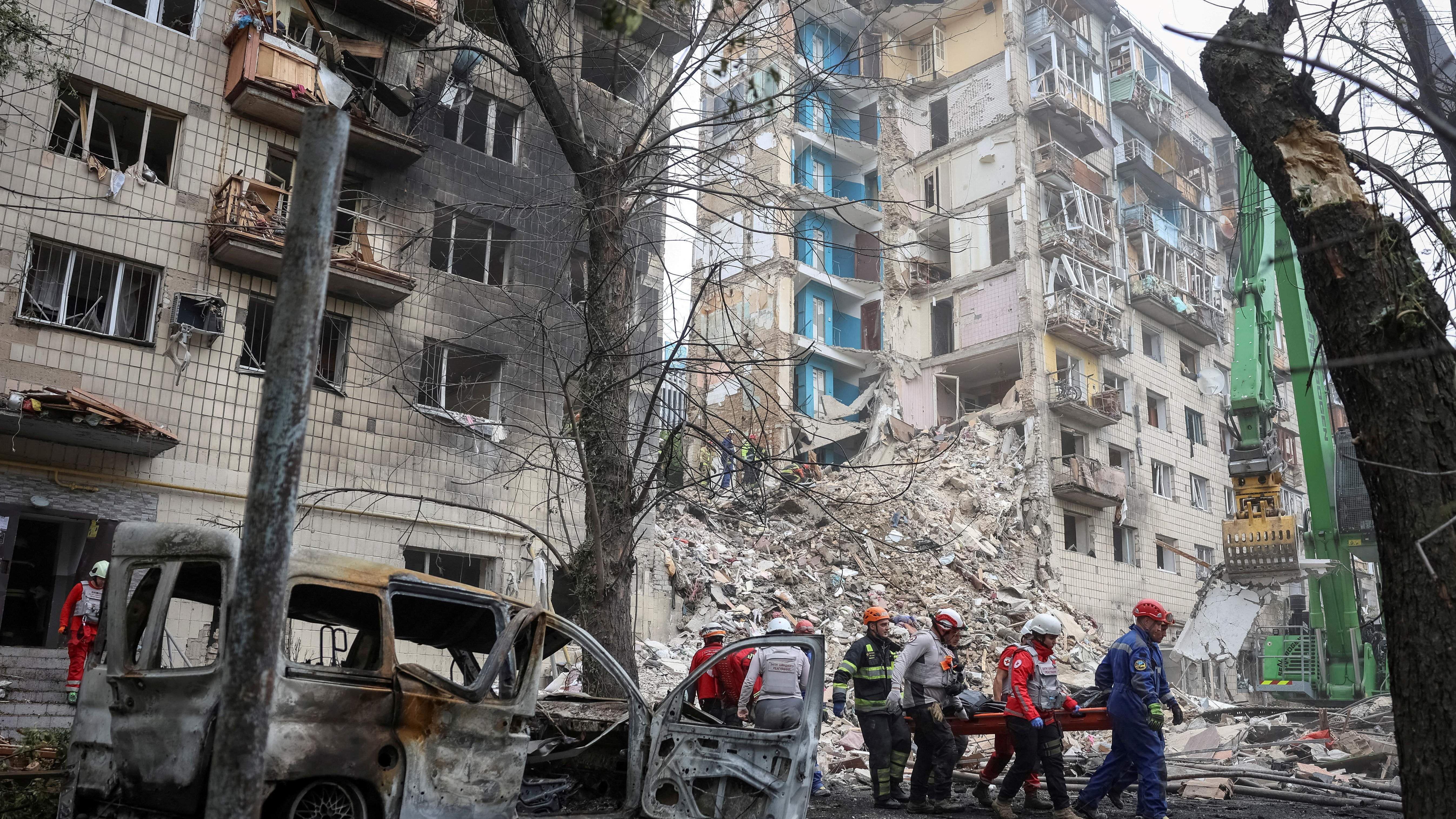 Imagen de socorristas transportando un cadáver en el lugar donde se encontraba un edificio de apartamentos en Kiev.