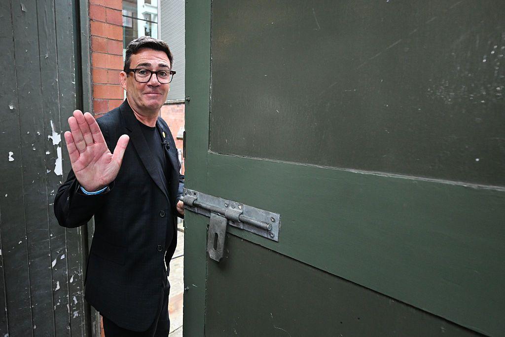 Vestindo terno preto e camiseta, Andy Burnham acena em despedida ao deixar o People's History Museum, em Manchester, Reino Unido, ap&oacute;s proferir um discurso, em 29 de junho de 2026.