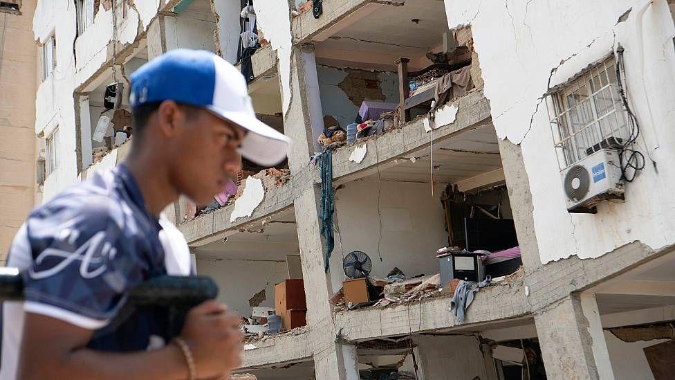 Un hombre en Venezuela pasa frente a un edificio que perdió totalmente su fachada dejando al descubierto el interior de los apartamentos dañados