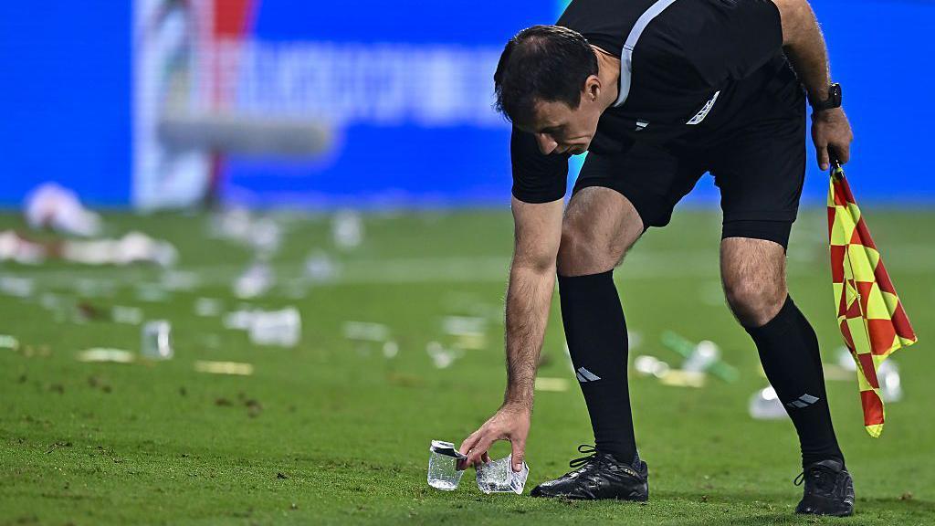Šta je zabranjeno na stadionima tokom Mundijala 2 Linijski sudija uklanja smeće sa fudbalskog terena rukama