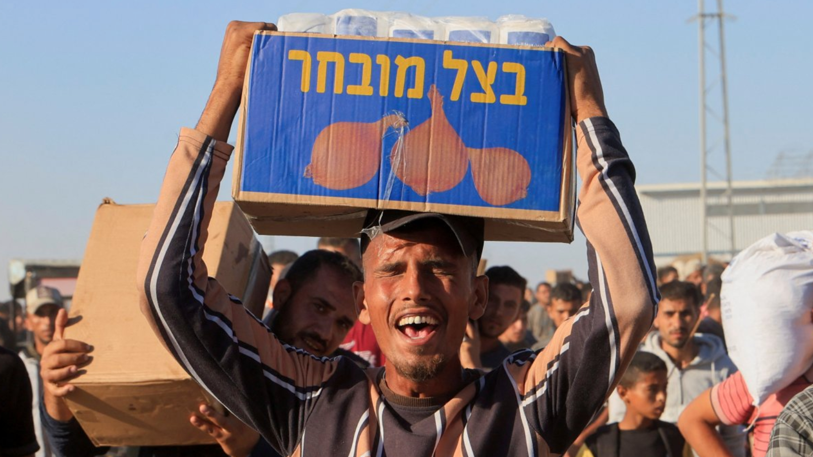 رجل فلسطيني يحمل صندوق مساعدات