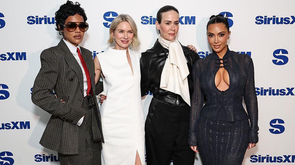 Teyana Taylor, Naomi Watts, Sarah Paulson y Kim Kardashian de pie, miran a la cámara. 