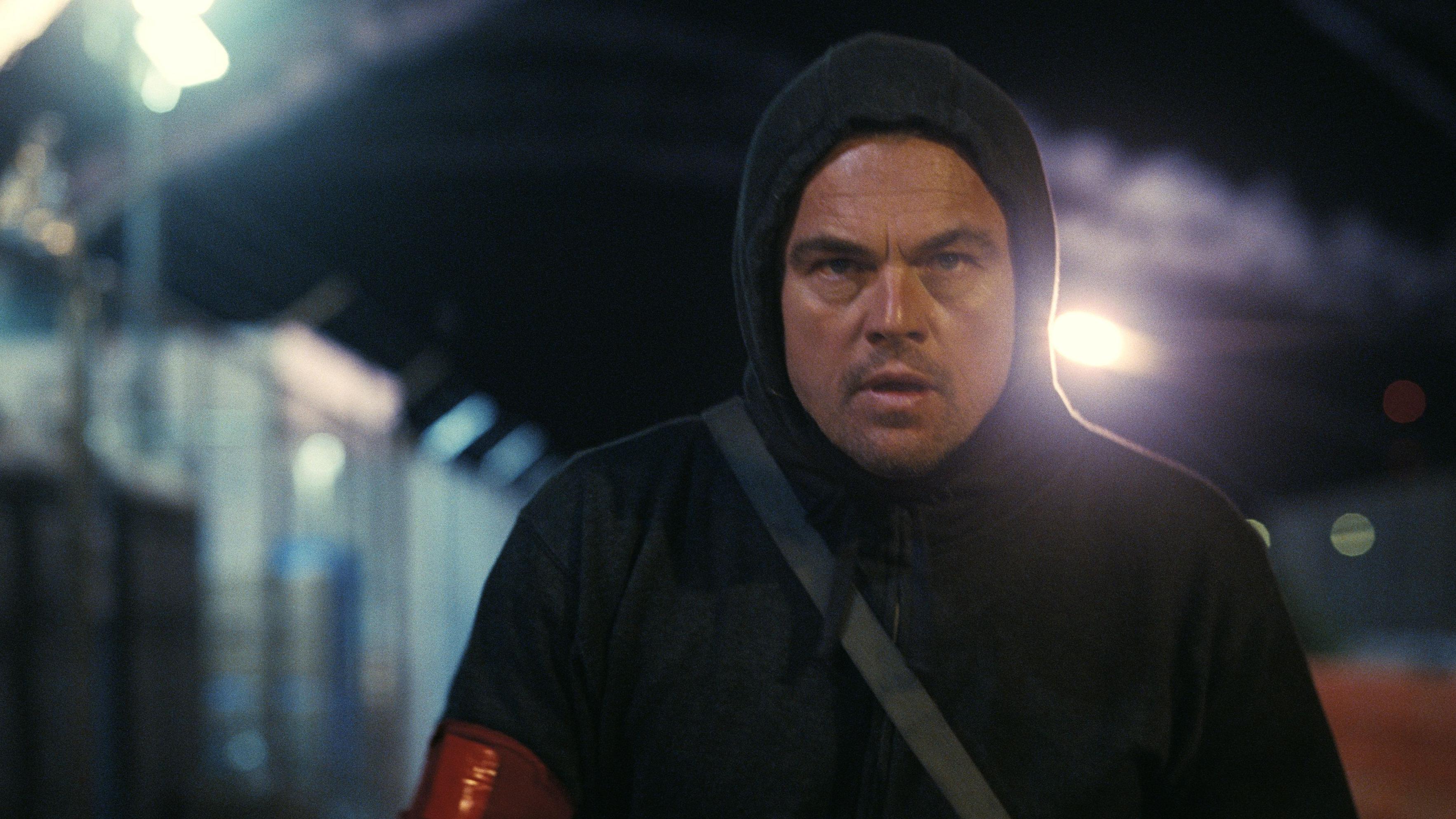 Cena do filme 'Uma Batalha Após a Outra' mostra o personagem de Leonardo DiCaprio vestindo um capuz preto e andando à noite
