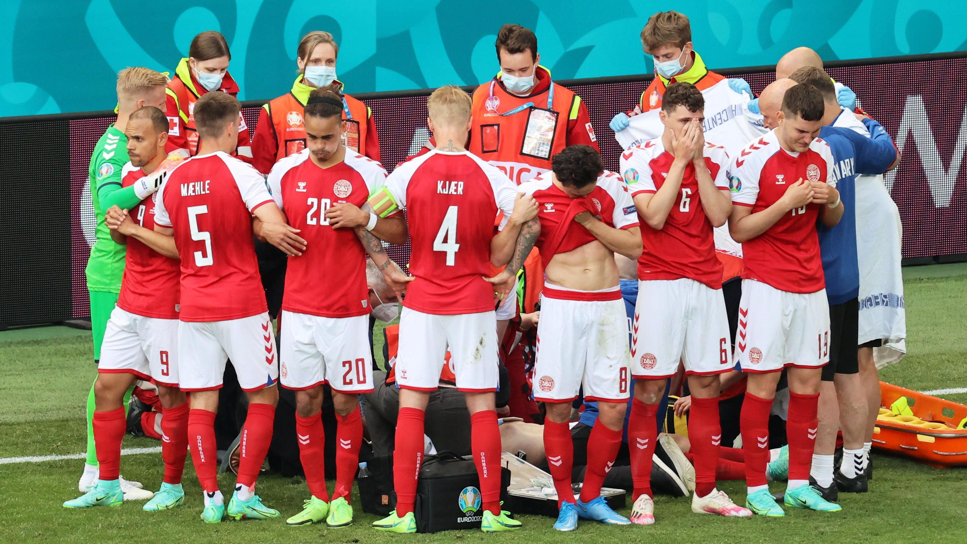 Los jugadores de Dinamarca forman un círculo para proteger a su compañero Christian Eriksen mientras recibe asistencia médica durante el partido del Grupo B de la Eurocopa 2020 entre Dinamarca y Finlandia en 2021.