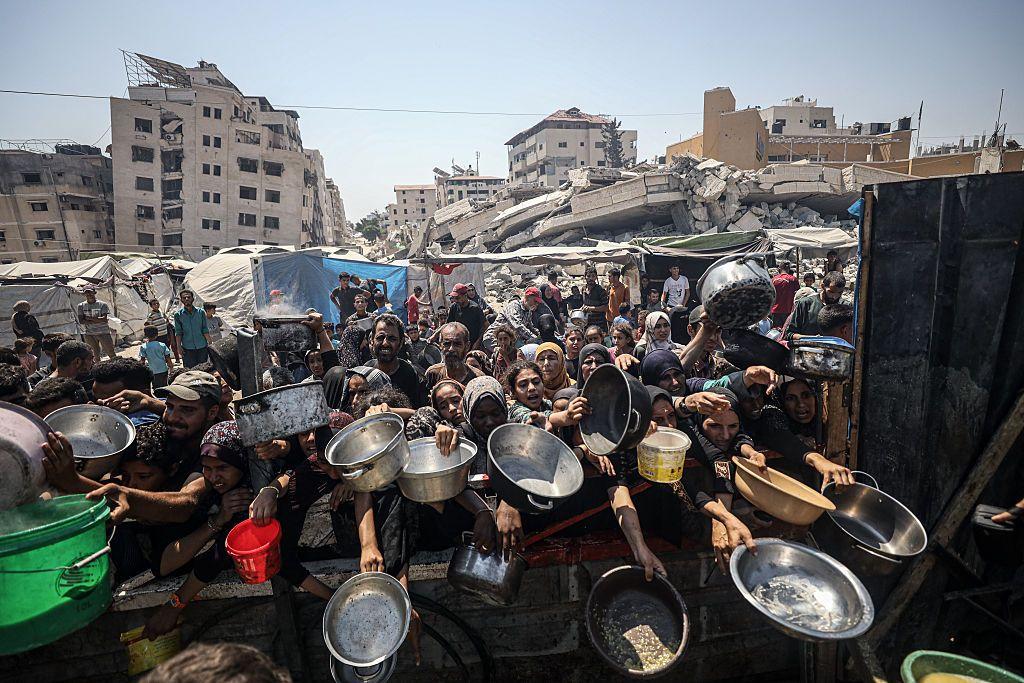 Un grupo de niñas y mujeres con sus platos a la espera de comida en Gaza