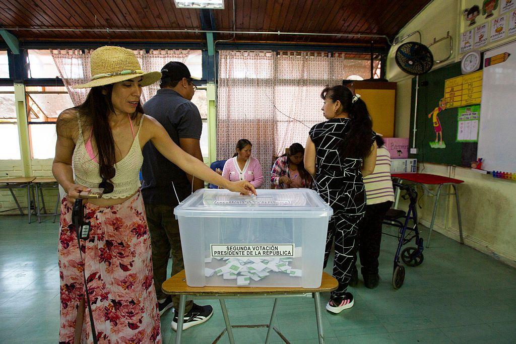Una mujer deposita su voto en una urna durante el balotaje presidencial chileno de diciembre de 2025.