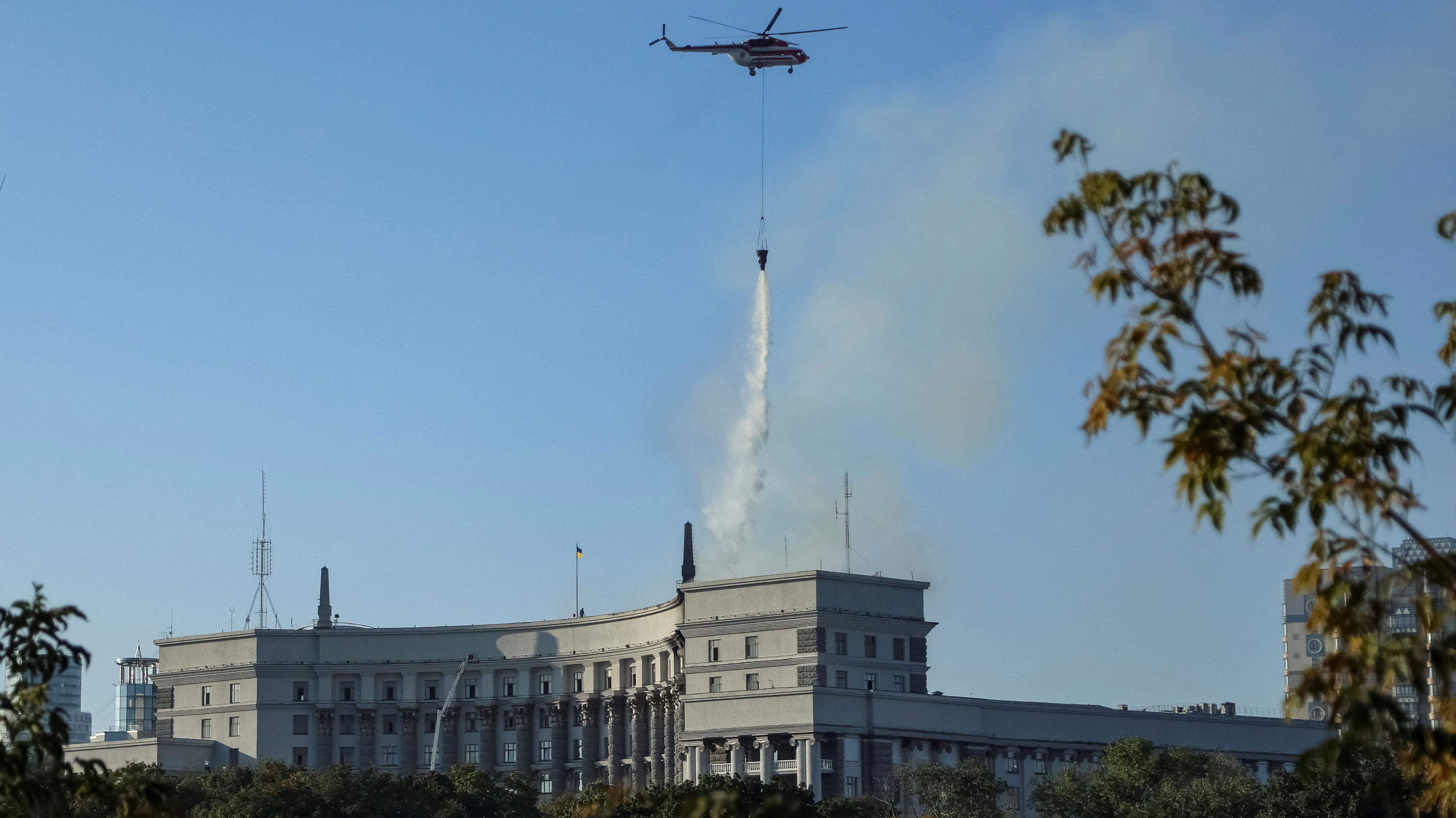 Un helicóptero arrojando agua para apagar las llamas de la sede gubernamental.