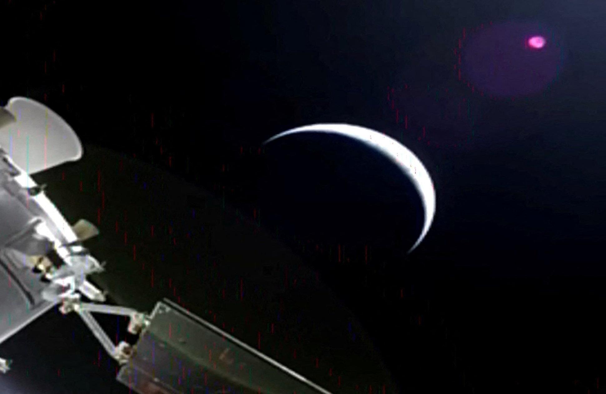 Blago zrnasta slika sa Oriona prikazuje planetu - možda Mesec, kao isečak, veći deo koji je u mraku, i deo Oriona u uglu.