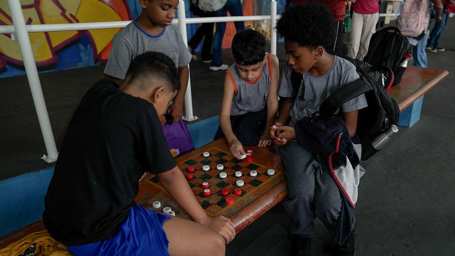 Niños juegan ajedrez en la escuela pública.