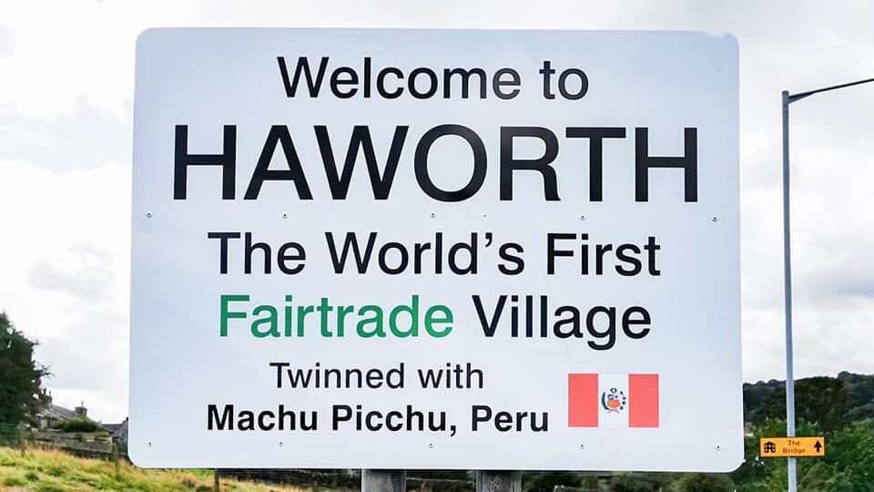 El letrero en inglés que indica que Haworth es el primer pueblo de Comercio Justo hermanado con Machu Picchu.
