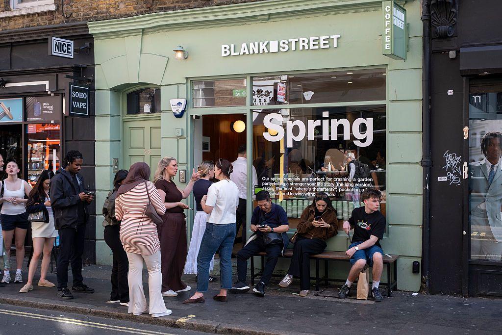 Clientes se sentam do lado de fora de um caf&eacute; Blank Street Coffee no Soho 