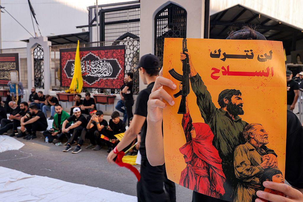 لافتة يرفعها أحد المشاركين في مسيرة لحزب الله تقول العبارة المكتوبة عليها لن نترك السلاح في وقت تتصاعد فيه الضغزط الأمريكية وضغوط أطراف سياسية داخلية على الحزب للتخلي عن سلاحه.