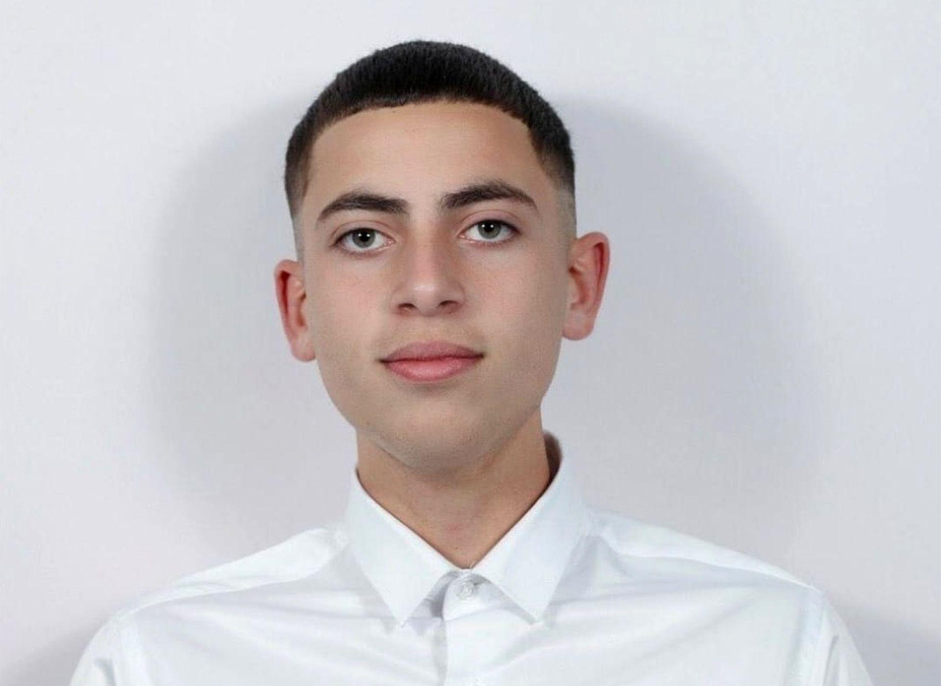 A teenage boy with short dark hair wearing a smart white shirt. He is looking at the camera and has a slight smile.