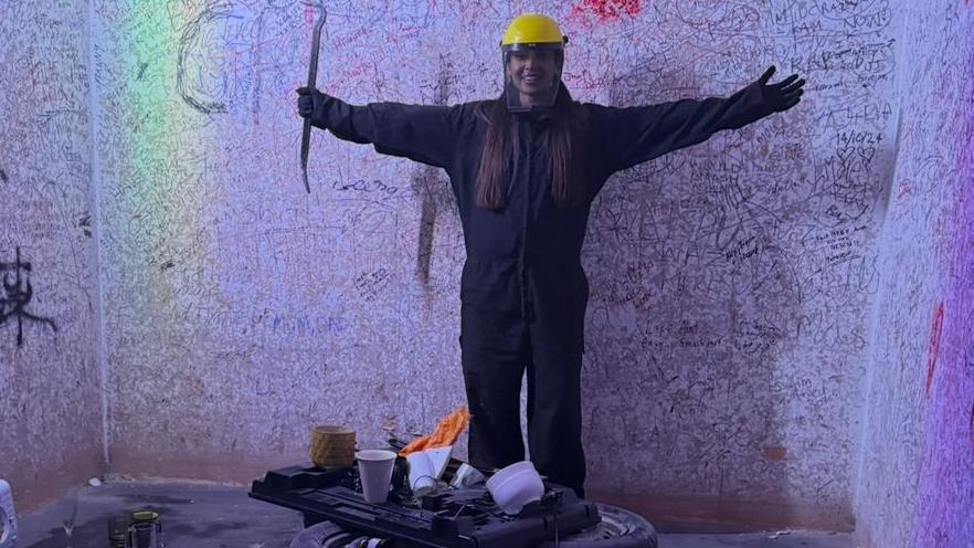 Imagen de una mujer en una sala de ira con ropa protectora.