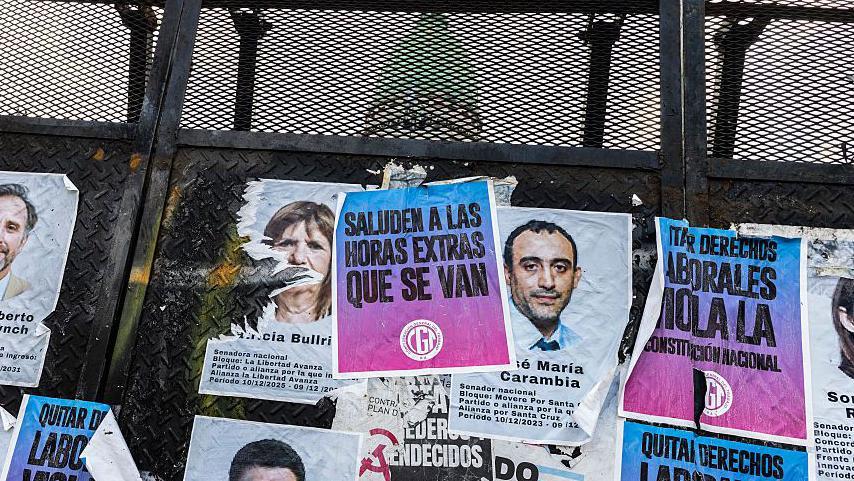 Carteles de legisladores que apoyan la reforma laboral y mensajes en contra de la nueva ley se ven pegados en las vallas de seguridad que rodean el Congreso.