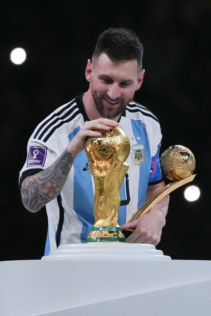 Lionel Messi acariciando o trof&eacute;u da Copa do Mundo ap&oacute;s a final da Copa de 2022, no Catar