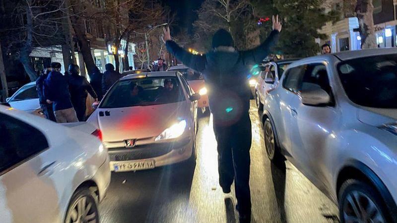 Un manifestante en medio de dos coches. 