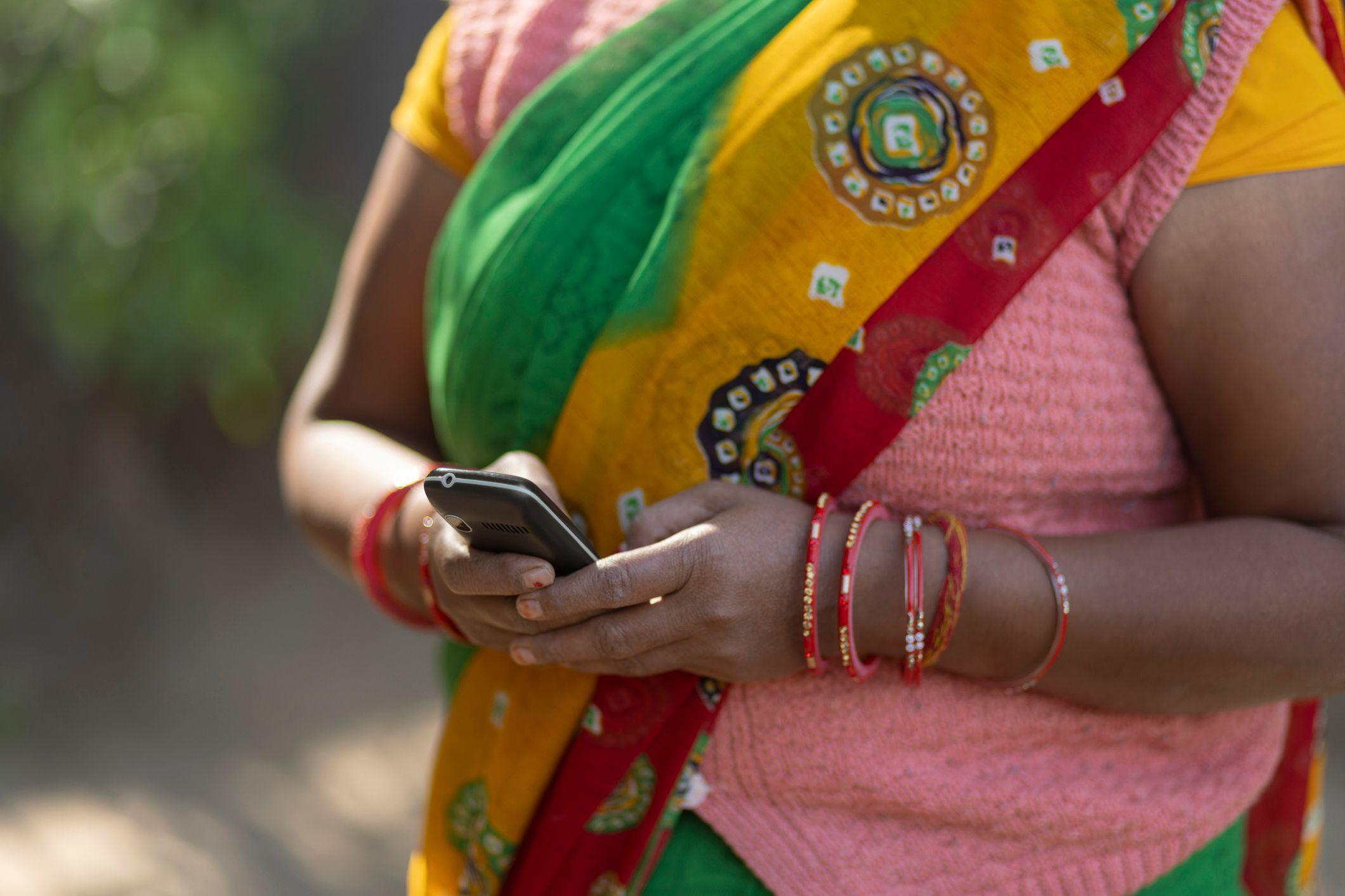 Closeup of the Hand of a house maid Using a Mobile Phone 