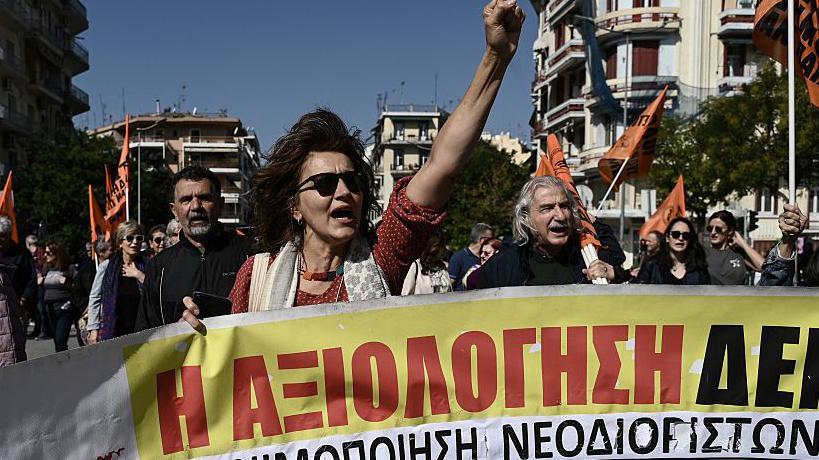 grupa ljudi nosi transparent na protestu u Grčkoj
