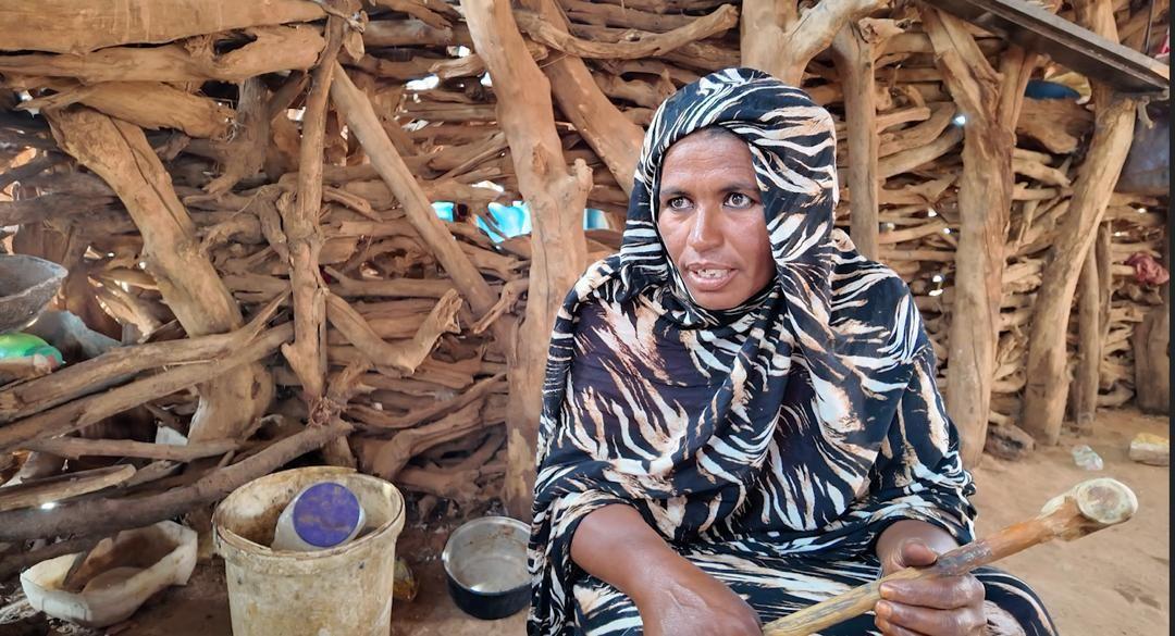 امرأة سودانية نازحة وبيدها عصا