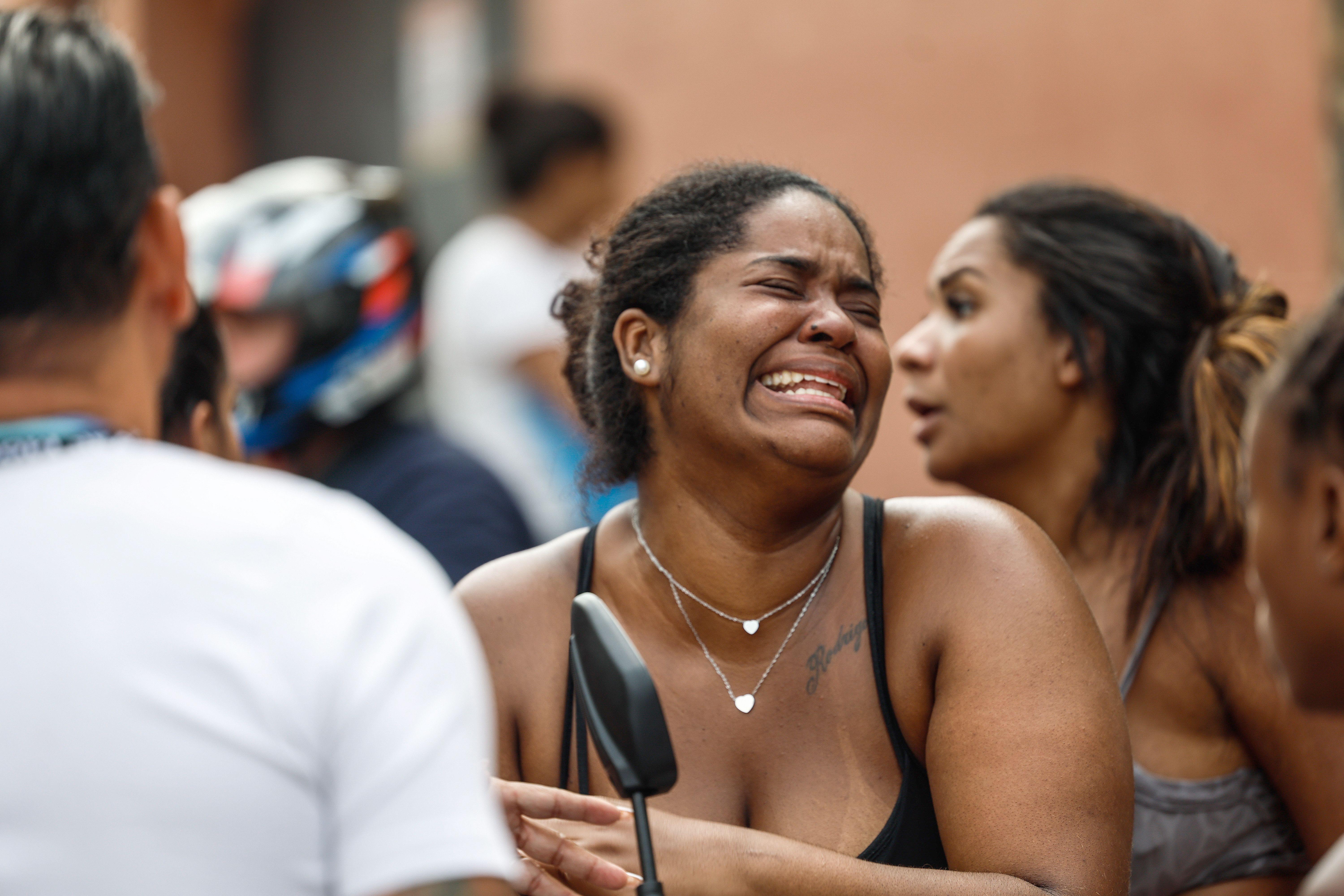 Una mujer llorando en la calle en medio de la muchedumbre.