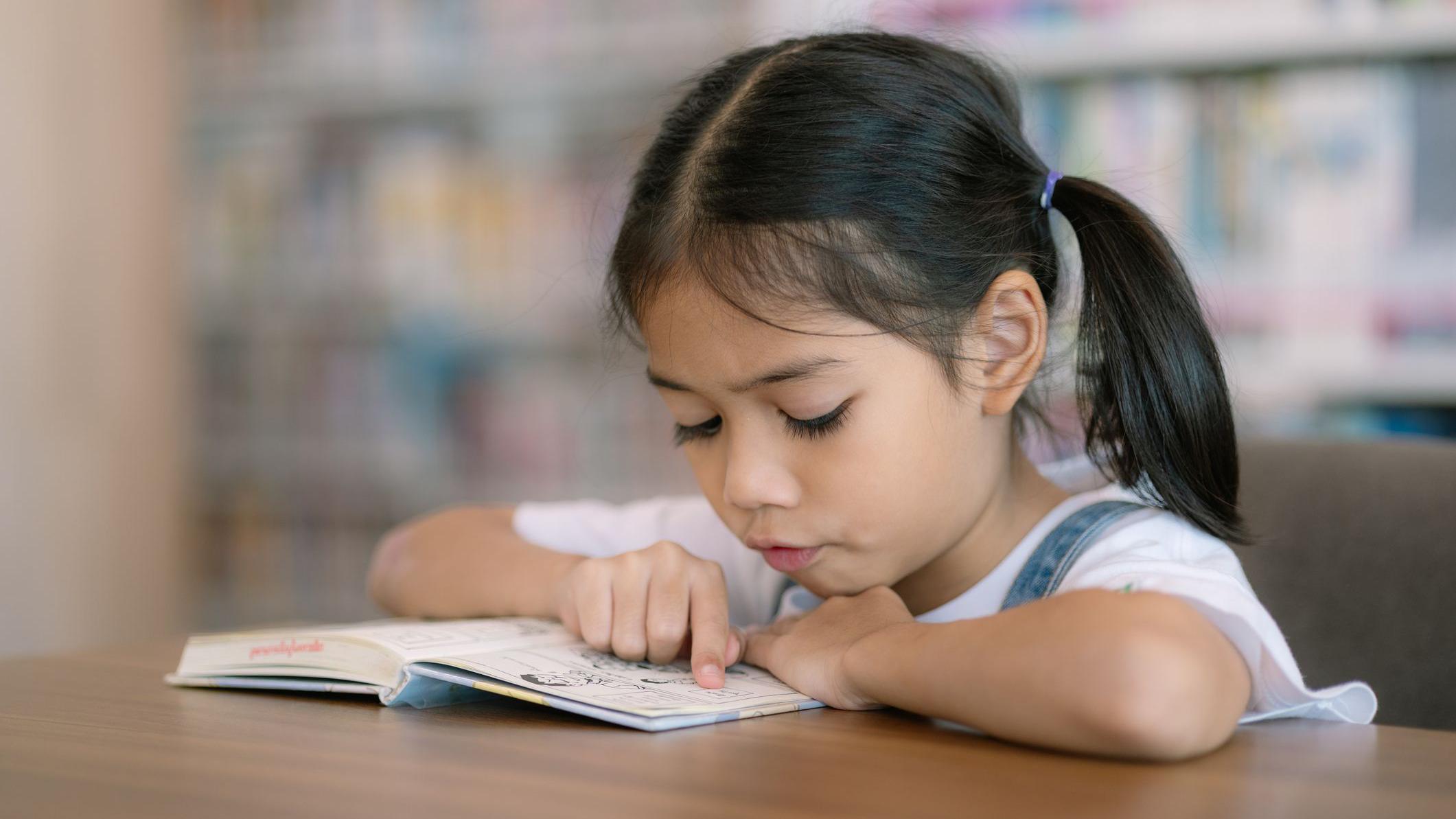Niña leyendo concentrada