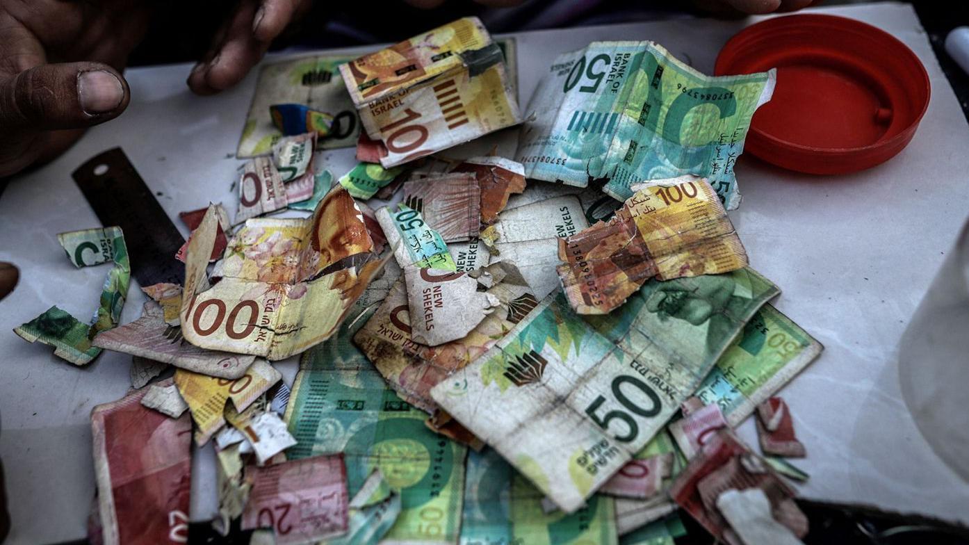 Un manojo de billetes desgastados sobre una mesa. 