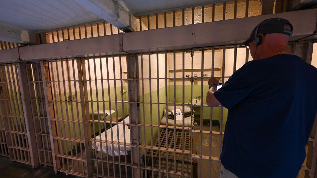 Seorang turis mengambil gambar sebuah sel di Alcatraz