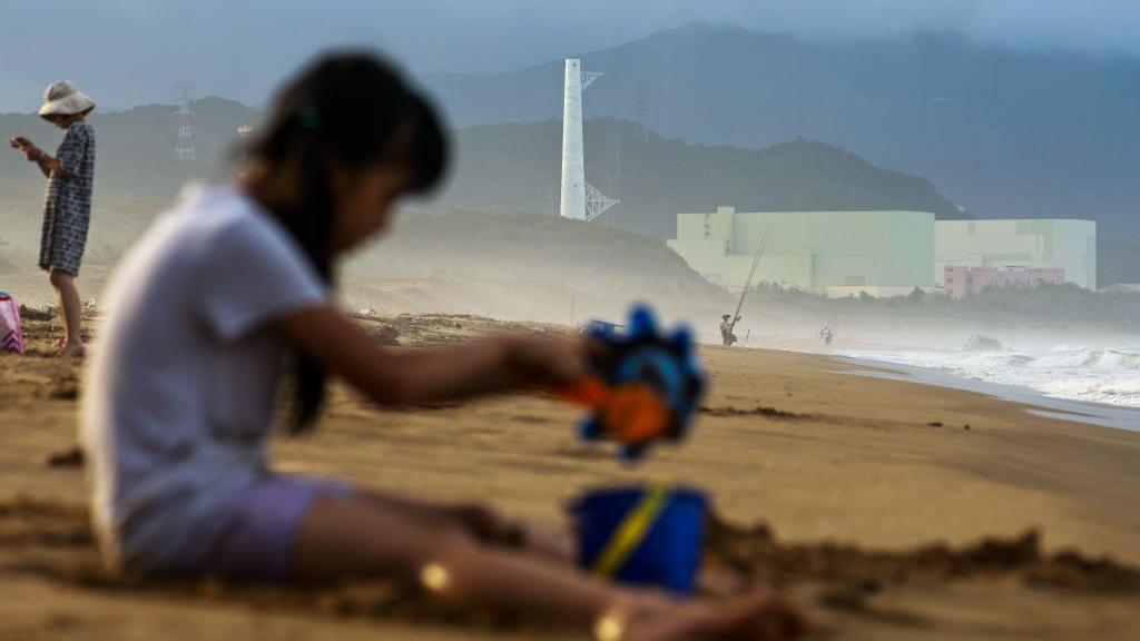 一名孩子在台灣南部沙灘、第三核電廠附近玩。