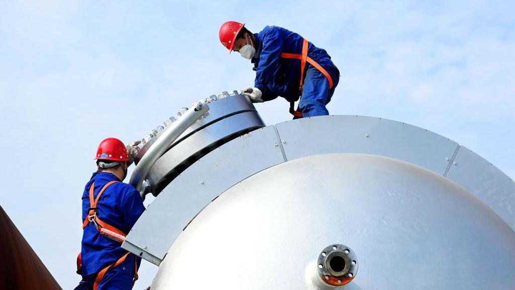Obreros de la construcción ensamblan equipos petroquímicos en la provincia de Shandong.
