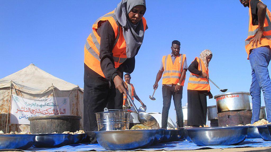 يُعِدّ متطوّعون سودانيون وجبات مجانية للنازحين من الفاشر في مخيم العفاض للنازحين في مدينة الدبة، شمالي السودان، في 20 نوفمبر/تشرين الثاني 2025.