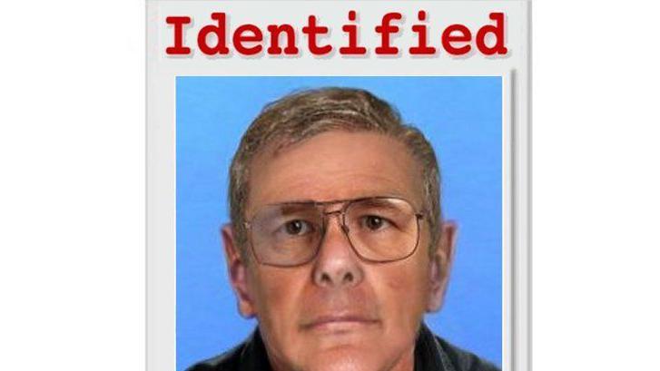 Un hombre con lentes y expresión neutra mira directamente a la cámara. Tiene el pelo canoso peinado hacia un lado. El fondo es azul. Sobre su rostro, la palabra "Identificado" está escrita en rojo y en inglés.