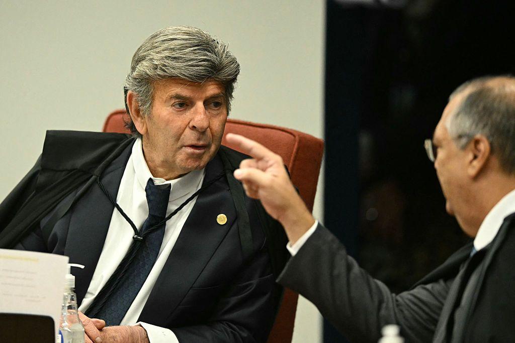 O ministro Luiz Fux (E) do Supremo Tribunal Federal (STF) ouve o colega Flavio Dino durante a sessão de votação para condenar ou absolver o ex-presidente de extrema direita (2019-2022) Jair Bolsonaro em um julgamento de golpe, em Brasília, em 9 de setembro de 2025