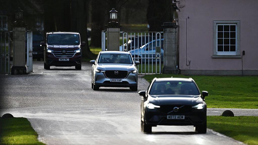 Vehículos sin distintivos se alejan de las puertas de la Logia Real, antigua residencia de Andrew Mountbatten-Windsor en Windsor Great Park, el 20 de febrero de 2026 en Windsor, Inglaterra. 