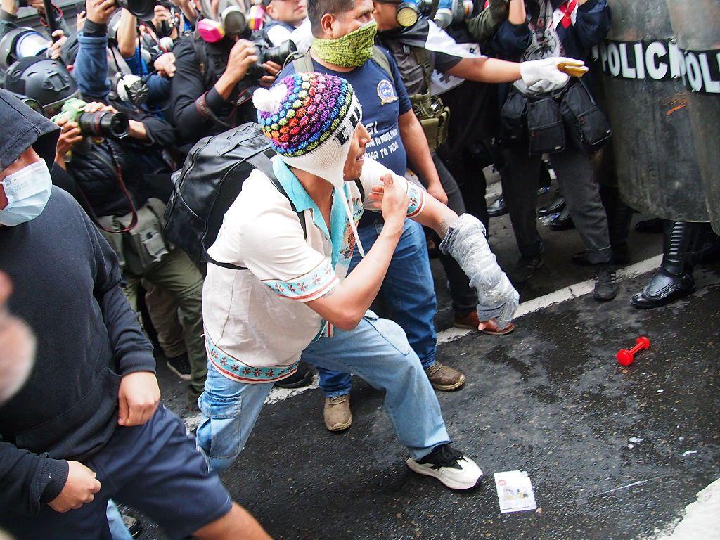 Un indígena se enfrenta a un cordón de la policía en Lima en una protesta
