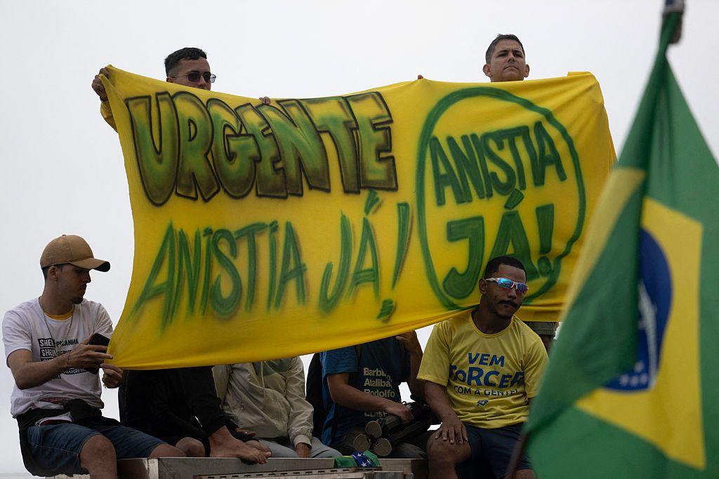 Apoiadores de Bolsonaro seguram uma faixa com os dizeres 