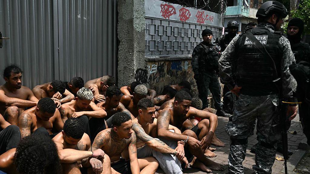 Agentes de policía custodian a presuntos delincuentes arrestados durante la Operación Contención en la favela Vila Cruzeiro, en el complejo Penha, Río de Janeiro, Brasil, el 28 de octubre de 2025.