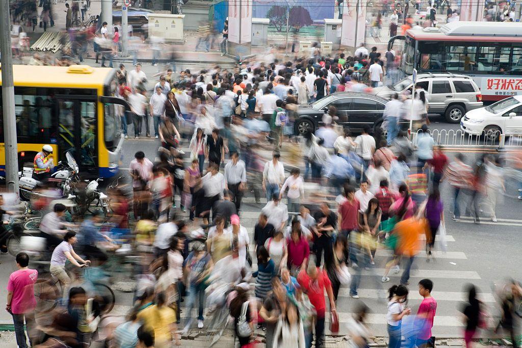 يتحوّل العدد الهائل من المشاة الذين يعبرون التقاطع المزدحم في منطقة التسوّق "سيدان" إلى كتلة ضبابية من الحركة مع حلول الغسق خلال عطلة عيد العمّال. ويُعدّ التسوّق أحد أكثر الأنشطة شيوعاً بين أبناء الطبقة الوسطى الجديدة في الصين.
