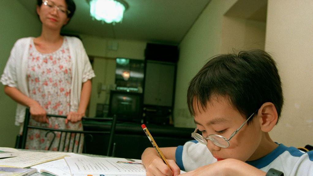 一個女人在輔導小孩做作業