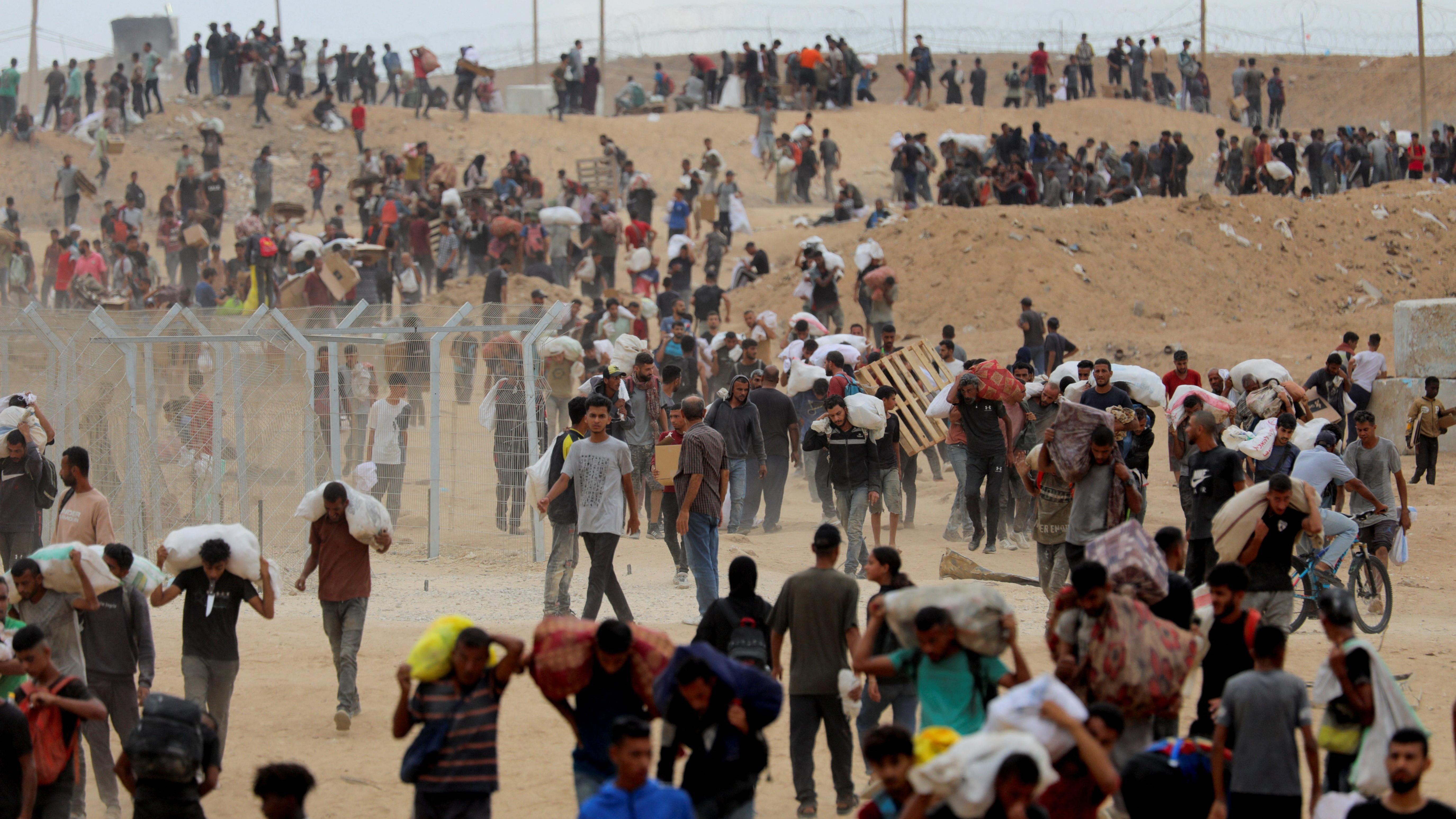 غزيون يحملون أكياس الطحين