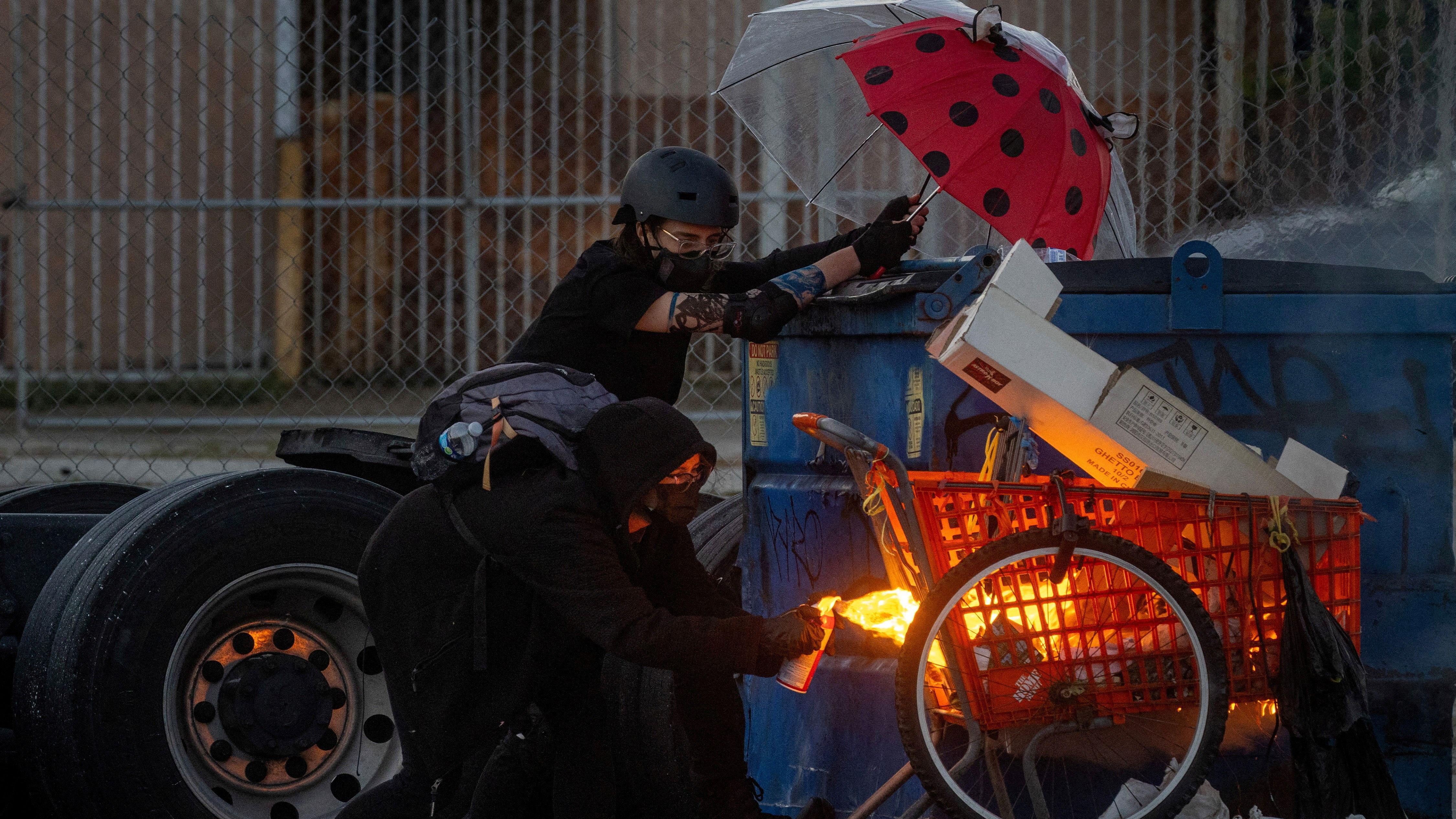 Un manifestante prende fuego a un carrito de compras durante un enfrentamiento con la policía.