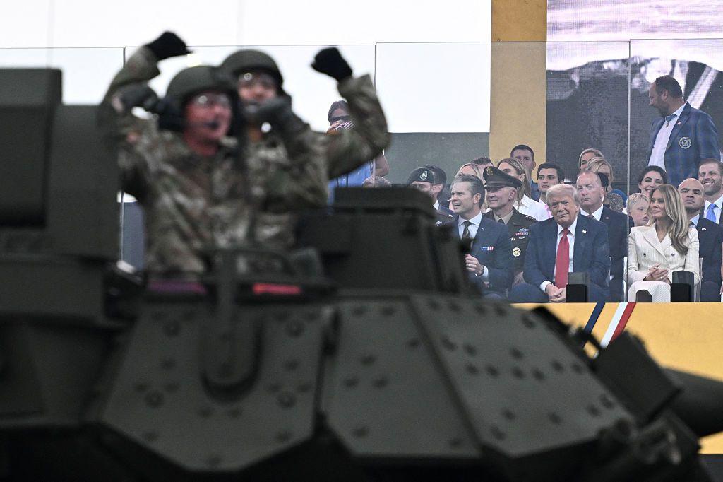 Soldados en un tanque en Estados Unidos saludan a la multitud mientras observa el presidente Donald Trump