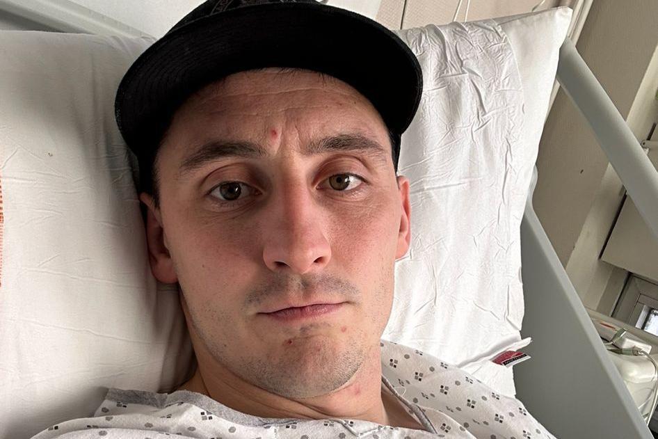 Sam Davies lying on a hospital bed 