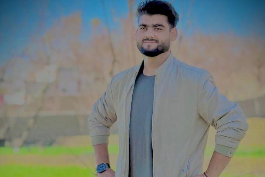 Qudratullah standing in a green field